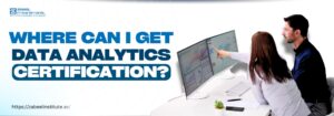 The image features two professionals sitting at a modern workspace, analyzing data visualizations on dual computer monitors. One person is pointing at the screen, highlighting key insights. The bold text "Where Can I Get Data Analytics Certification?" is prominently displayed, emphasizing the topic. The website link "https://zabeelinstitute.ae/" is included, suggesting an educational resource for obtaining certification in data analytics.