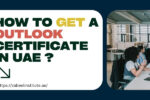 A promotional blog banner with the text "How to get an Outlook certificate in UAE?" in bold, colorful font. The image includes two office scenes: one showing a small group discussing work over laptops, and the other showing a team meeting in a modern conference room. The website URL “https://zabeelinstitute.ae/” is displayed below the main text.