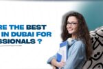 A blog banner image featuring the text 'What are the best courses in Dubai for professionals?' in bold blue font. A smiling young woman holding folders and headphones stands in front of a modern structure with Arabic calligraphy. Website link: https://zabeelinstitute.ae/