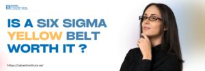 Is a Six Sigma Yellow Belt Worth It? A thoughtful-looking woman with glasses, dressed in black, poses against a white background. Bold text on the left reads: “IS A SIX SIGMA YELLOW BELT WORTH IT?” with “YELLOW BELT” highlighted in yellow. Zabeel Institute logo is at the top left, and the website link https://zabeelinstitute.ae/ appears at the bottom.