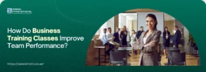 A banner image with a dark green background and light green text on the left side, and a professional-looking woman smiling at the camera on the right side. The text on the left reads "ZABEEL INTERNATIONAL INSTITUTE OF MANAGEMENT & TECHNOLOGY" at the top, followed by the question "How Do Business Training Classes Improve Team Performance?". Below this is the website address "https://zabeelinstitute.ae/". The woman on the right is in a business setting, possibly a classroom or seminar, with other people in the background. She is wearing a grey plaid blazer over a white shirt and has her arms crossed, exuding confidence. The lighting is soft and professional.