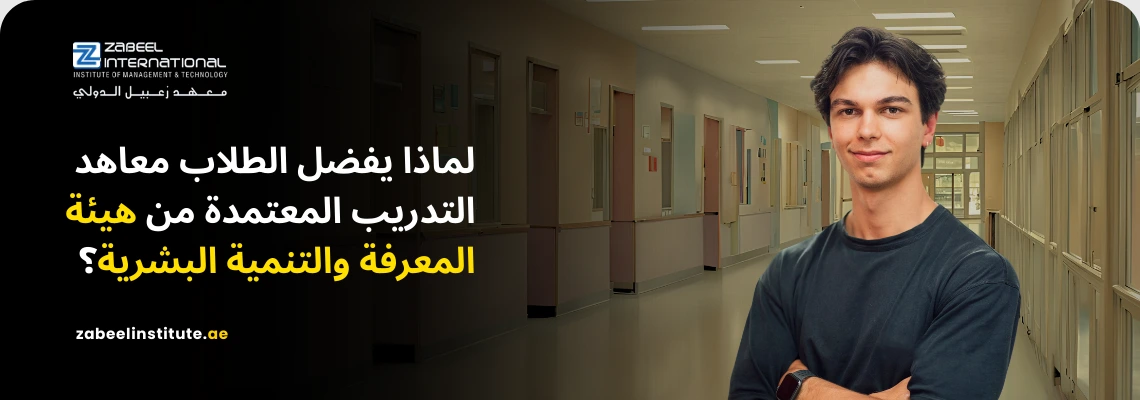 صورة لشاب يبتسم بثقة في ممر معهد تعليمي، يمثل الطلاب الباحثين عن جودة التعليم والاعتماد الرسمي في دولة الإمارات. يظهر في الصورة سؤال باللغة العربية: "لماذا يفضل الطلاب معاهد التدريب المعتمدة من هيئة المعرفة والتنمية البشرية؟" مع شعار "Zabeel International" والموقع الإلكتروني للمعهد. تعكس الصورة أهمية اختيار المعاهد الموثوقة والمعتمدة من KHDA لضمان جودة التدريب في دبي.