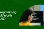 Educational banner from Zabeel International Institute asking 'Why Are C Programming Essentials Still Worth Learning in UAE?', featuring a student viewing lines of code on multiple monitors to highlight C programming courses and software development training.